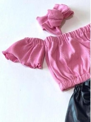 Özge Başaran Kız Çocuk, Likralı Deri Fiyonk Detaylı Pantolon, Pembe Straplez Crop Bluz ve Saç Bandı Takımı.