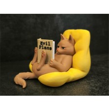 Minimal Kedi Dekoru – Koltukta Oturan Kitap Okuyan Kedi