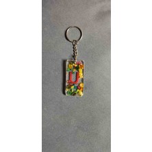 Miina Aksesuar Kurutulmuş Çiçeklerle Süslenmiş Epoksi Malzemeden Üretilmiş Kişiselleştirilmiş Bir Harf Anahtarlıktır.