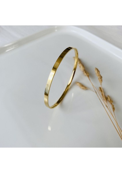 Altın tonlu sağlam çelik tek bilezik, şık ve dayanıklı aksesuar.