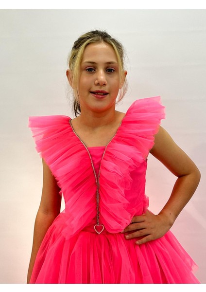 Kız Çocuk Abiye Neon Pembe Uzun Kat Etekli Kolları Fırfırlı Yakası Taş Detaylı Kalp Tokalı Abiye Elbise 10-14 Yaş indirimleri