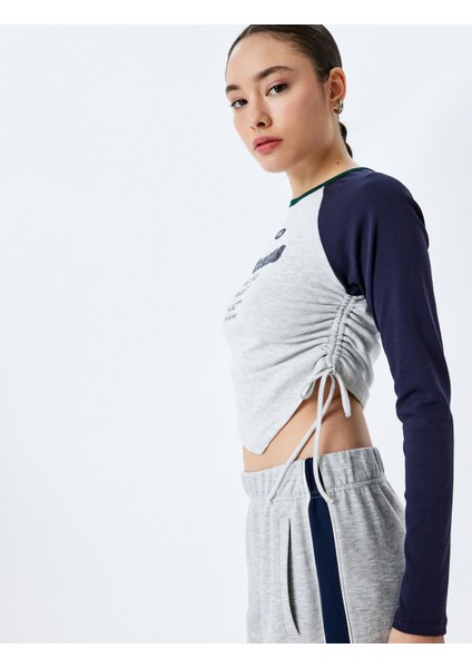 Uzun Reglan Kol Slim Fit Kolej Baskılı Büzgülü Asimetrik Crop Tişört