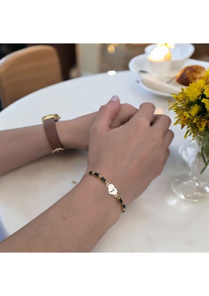 Kalp Motifli ve Parlak Siyah Taşlı 14 Ayar Altın Plakalı Harfe Özel Bileklik fiyatları