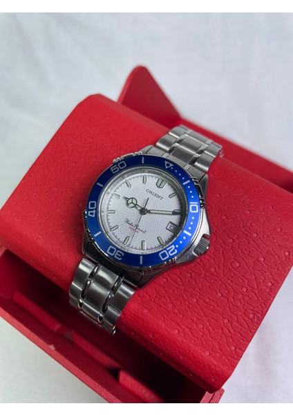 BS9020251122A Retro Model Yuvarlak Metalik Kasa Mavi Çerçeveli Takvimli Gri Kadranlı Şık Erkek Kol Saati