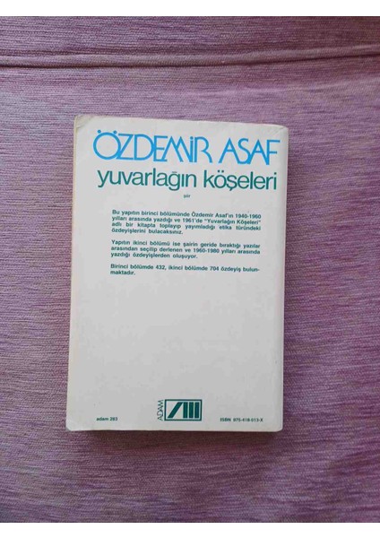 Özdemir Asaf'ın 'yuvarlağın Köşeleri' Adlı Romanı, Beyaz Kapak Üzerine Mavi ve Yeşil Yazılı Sade Tasarım Içerir. modelleri