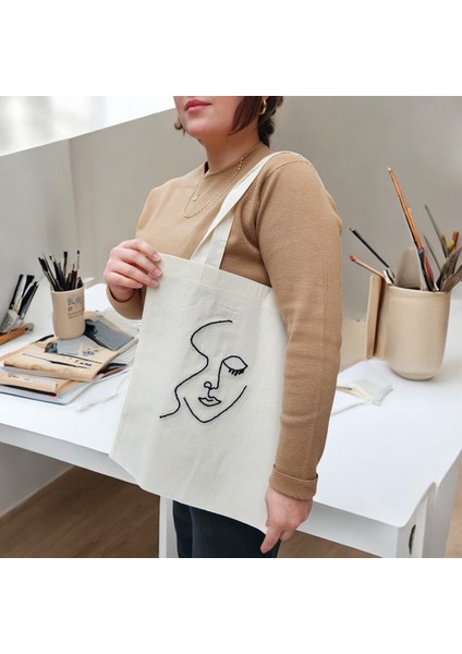 Göksunun Izi - Minimal Yüz Figürlü Punch Bez Çanta – Sanatsal Çizgilerle El Yapımı Minimalist Omuz Çantası fiyatları