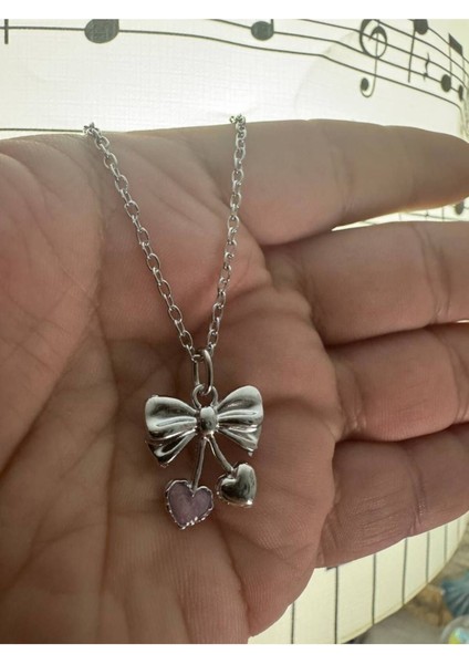 Pembe Taşlı Kalp Fiyonk Desen Unisex Kolye – Metal Zincirli, Romantik ve Zarif Tasarım