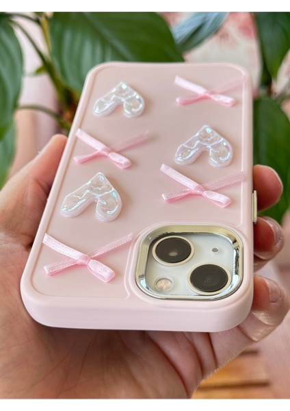 Apple iPhone 13 - 14 - 15 Kılıf Kamera Çıkıntılı Kalpli Fiyonk Desenli Pembe Yumuşak Silikon Kapak