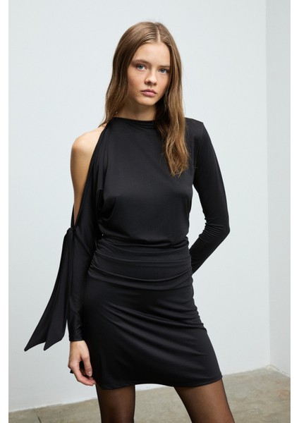 ASSETRA Kadın Yuvarlak Yakalı Esnek Kumaşlı Tek Omuzu Açık Bağlama Detaylı Mini Siyah Elbise